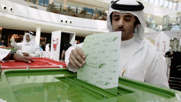 A voter casts his vote during parliamentary elections, at a polling station set up at the Seef Mall shopping centre in Manama November 22, 2014 - Sputnik International