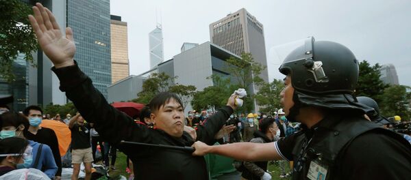 A pro-democracy protester blocks a riot policeman during a clash outside the government headquarters in Hong Kong - Sputnik International