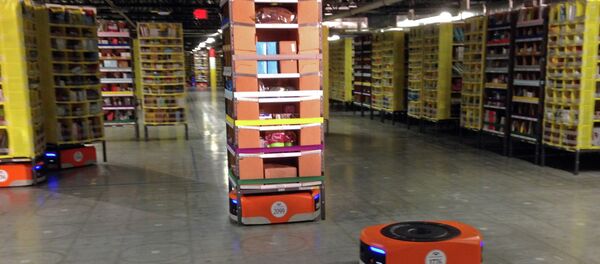 A Kiva robot drive unit is seen, foreground, before it moves under a stack of merchandise pods, seen on a tour of one of Amazon's newest distribution centers in Tracy A Kiva robot drive unit is seen, foreground, before it moves under a stack of merchandise pods, seen on a tour of one of Amazon's newest distribution centers in Tracy - Sputnik International