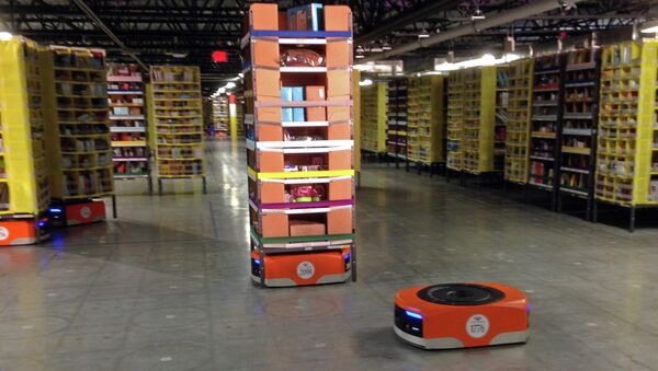 A Kiva robot drive unit is seen, foreground, before it moves under a stack of merchandise pods, seen on a tour of one of Amazon's newest distribution centers in Tracy - Sputnik International