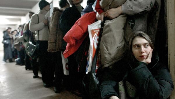 In this image dated Jan.28, 2004, showing a Romanian woman as she leans against the door at the International Office for Migration in Bucharest, Romania, Jan. 28, 2004, waiting in a line to apply for a job in Spain - Sputnik International