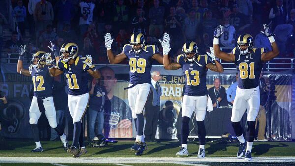 St. Louis Rams wide receiver Stedman Bailey (12), wide receiver Tavon Austin (11), tight end Jared Cook (89), wide receiver Chris Givens (13) and wide receiver Kenny Britt (81) put their hands up to show support for Michael Brown before a game against the Oakland Raiders at the Edward Jones Dome in St Louis November 30, 2014. - Sputnik International