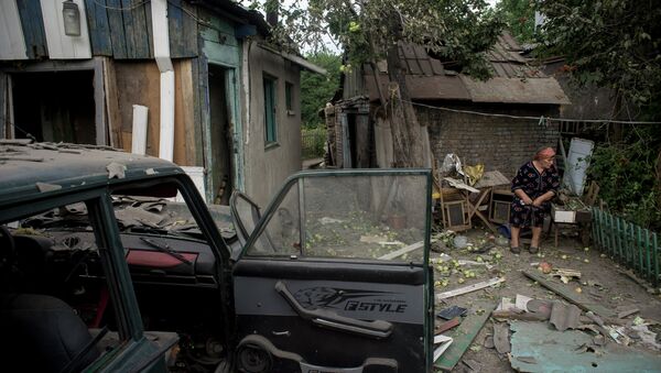 Luhansk resident near her house destoyed as result of the shelling by Ukraine's armed forces. - Sputnik International