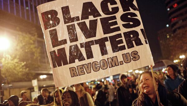Protesters hold a sign during a march against the New York City grand jury decision to not indict in the death of Eric Garner, in Oakland, California December 3, 2014. - Sputnik International