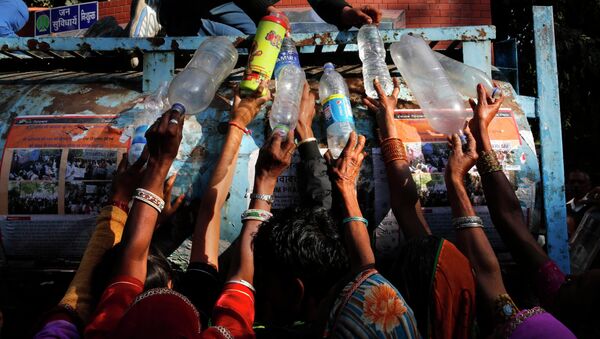 Indian women protesters from the Indian state fill their bottles with drinking water as they participate in a rally in New Delhi, India, Tuesday, Dec. 2, 2014 - Sputnik International