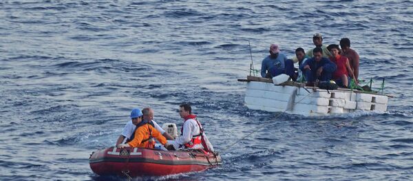 Italian rescuers boarded a merchant ship, with as many as 450 migrants, lost in rough waters off the coast southeast of Italy, the BBC reports. - Sputnik International