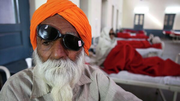 A man sits on a bed while waiting for treatment at a hospital after undergoing cataract removals from a free eye surgery camp, in the northern Indian city of Amritsar - Sputnik International