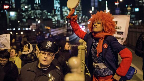 A female protester, demanding justice for Eric Garner, plays the tambourine as she and others enter Brooklyn over the Brooklyn Bridge in New York City December 4, 2014 - Sputnik International