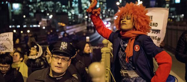 A female protester, demanding justice for Eric Garner, plays the tambourine as she and others enter Brooklyn over the Brooklyn Bridge in New York City December 4, 2014 - Sputnik International