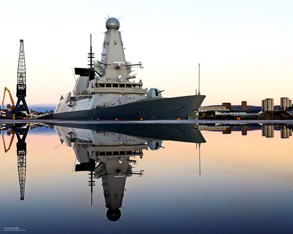 Royal Navy Type 45 destroyer HMS Defender is mirrored in water following a downpour on the dockside - Sputnik International