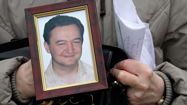 Portrait of lawyer Sergei Magnitsky who died in jail, is held by his mother Nataliya Magnitskaya, as she speaks during an interview with the AP in Moscow - Sputnik International