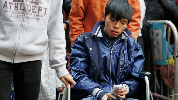 Student leader Joshua Wong attends a news conference as he sits on a wheel chair - Sputnik International