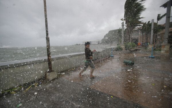 A man reacts as he strong winds and rain from Typhoon Hagupit hit shore in Legazpi, Albay province, eastern Philippines on Sunday, Dec. 7, 2014 - Sputnik International