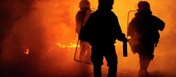 Riot police are seen through a cloud of smoke during clashes with masked youths occupying the Labour Center of Thessaloniki December 6, 2014 - Sputnik International