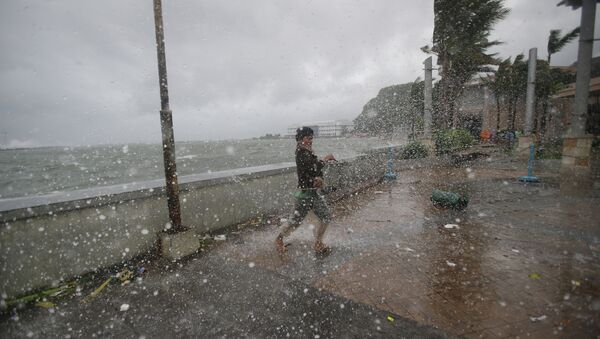 A man reacts as he strong winds and rain from Typhoon Hagupit hit shore in Legazpi, Albay province, eastern Philippines on Sunday, Dec. 7, 2014 - Sputnik International