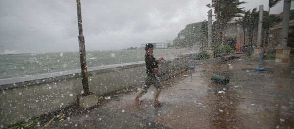 A man reacts as he strong winds and rain from Typhoon Hagupit hit shore in Legazpi, Albay province, eastern Philippines on Sunday, Dec. 7, 2014 - Sputnik International