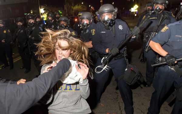 A protester flees as police officers try to disperse a crowd comprised largely of student demonstrators during a protest against police violence in the U.S., in Berkeley, California early December 7, 2014 - Sputnik International