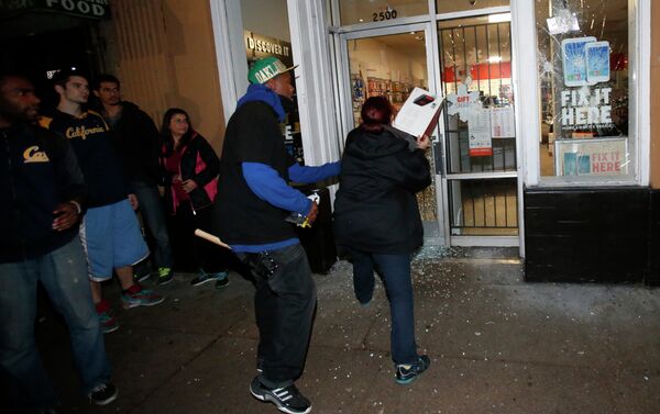 A woman attempts to toss back merchandise into a Radio Shack after it was vandalized during a march against the New York City grand jury decision to not indict a police officer in the death of Eric Garner, in Berkeley, California December 7, 2014 - Sputnik International