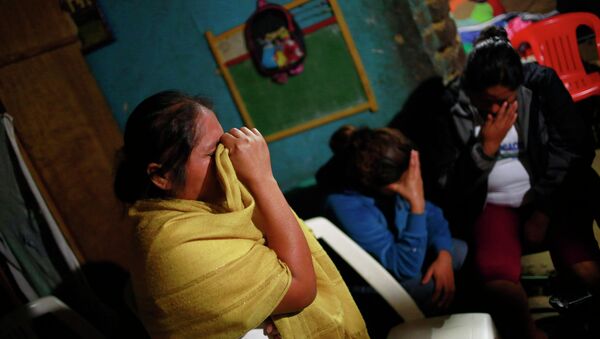 Edith Mora Mora Venancio, sister of Alexander Mora Venancio mourns next to others women at their house in El Pericon, in the southern Mexican state of Guerrero, December 6, 2014 - Sputnik International