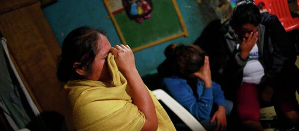 Edith Mora Mora Venancio, sister of Alexander Mora Venancio mourns next to others women at their house in El Pericon, in the southern Mexican state of Guerrero, December 6, 2014 - Sputnik International
