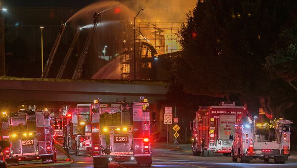 Los Angeles County firefighters battle a fire at an apartment building under construction next to the Harbor CA-110 Freeway in Los Angeles, early Monday, Dec. 8, 2014 - Sputnik International