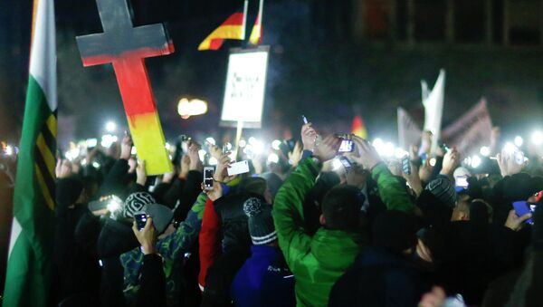 Participants hold up their mobile phones during a demonstration called by anti-immigration group PEGIDA, a German abbreviation for Patriotic Europeans against the Islamization of the West, in Dresden December 8, 2014. - Sputnik International