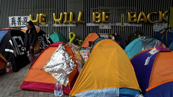 A pro-democracy protester walks past tents outside the government headquarters at Admiralty in Hong Kong December 10, 2014. - Sputnik International