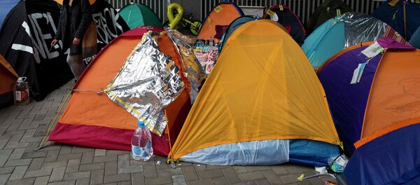 A pro-democracy protester walks past tents outside the government headquarters at Admiralty in Hong Kong December 10, 2014. - Sputnik International