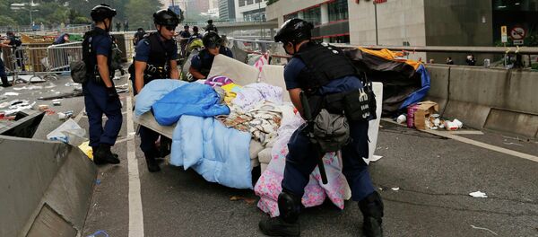 Police remove a sofa as they clear an area previously blocked by pro-democracy protesters near the government headquarters building at the financial Central district in Hong Kong, December 11, 2014 Police remove a sofa as they clear an area previously blocked by pro-democracy protesters near the government headquarters building at the financial Central district in Hong Kong, December 11, 2014 - Sputnik International