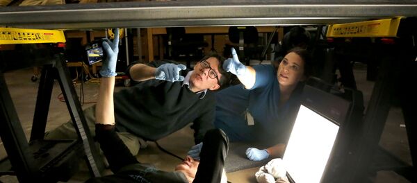 JP Brown, Regenstein Conservator at the Field Museum, left, and assistant conservator Morgan Nau, right, assist conservator Mimi Leveque, from Salem, Mass., as they prepare to photograph of the backside of the mummified body of Minirdis, a 14-year-old Egyptian boy who was the son of a priest, Wednesday, Dec. 10, 2014, in Chicago. - Sputnik International