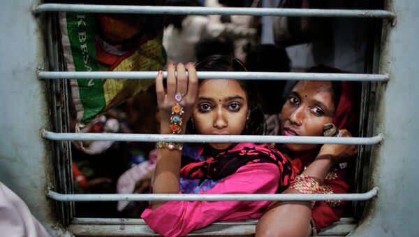 Murshida, 12, sits on the lap of her mother Marjina as the train leaves for their village in West Bengal, at a railway station in New Delhi, India - Sputnik International