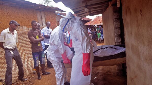 Ebola health care workers carry the body of a man suspected of dying from the Ebola virus in a small village Gbah on the outskirts of Monrovia, Liberia - Sputnik International