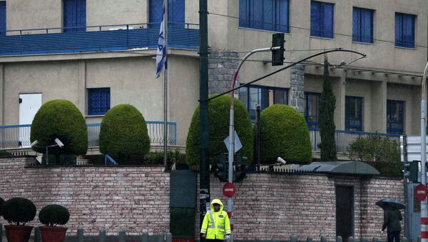 A police officer stands guard as a forensics officer (R) looks for evidence in front of the Israeli embassy in Athens December 12, 2014. - Sputnik International