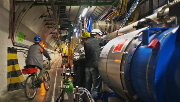 An engineer on a bicycle provided for tunnel transportation rides past engineers working on the Large Hadron collider in the 27Km circular tunnel at CERN near Geneva amid a scheduled 2013 shutdown. - Sputnik International