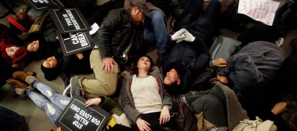 Protesters rallying against a grand jury's decision not to indict the police officer involved in the death of Eric Garner stage a die-in at the Apple Store on Fifth Avenue Protesters rallying against a grand jury's decision not to indict the police officer involved in the death of Eric Garner stage a die-in at the Apple Store on Fifth Avenue - Sputnik International