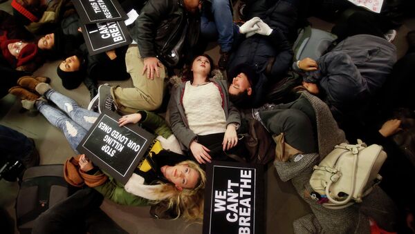 Protesters rallying against a grand jury's decision not to indict the police officer involved in the death of Eric Garner stage a die-in at the Apple Store on Fifth Avenue - Sputnik International