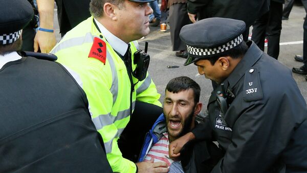 A demonstrator clashes with the police in Parliament Square in London - Sputnik International