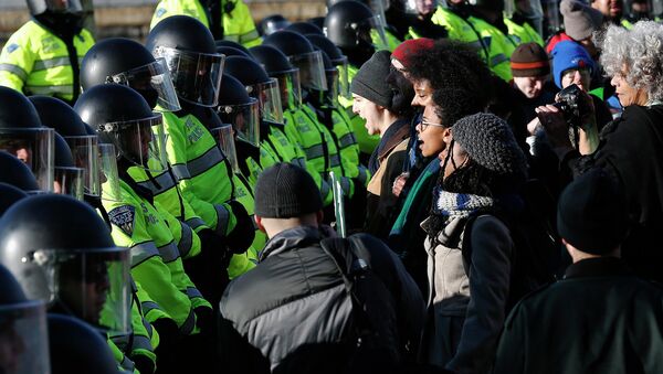Demonstrators face a line of police officers during a demonstration against recent grand jury decisions not to indict police officers in the deaths of Michael Brown and Eric Garner, in Boston, Massachusetts December 13, 2014 - Sputnik International