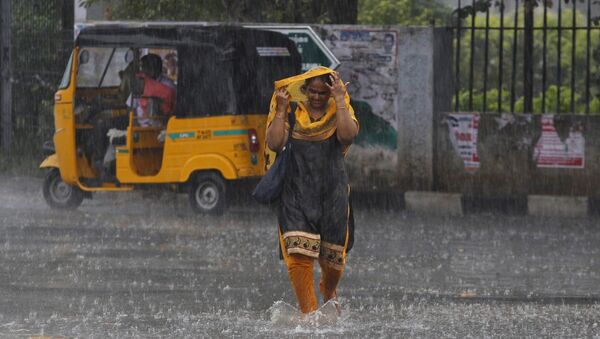 An Indian woman walks in the rain in Chennai, India, Archiv photo. - Sputnik International