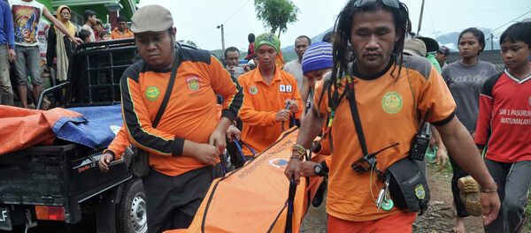 Rescue workers carry the body of a landslide victim at Pasuruhan village in Wonosobo December 12, 2014 - Sputnik International