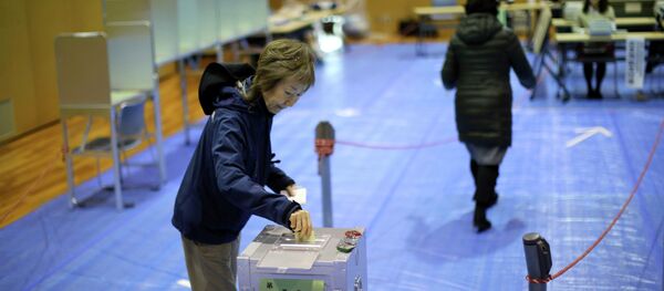 A woman casts her vote in Japan's parliamentary elections at a polling station in Tokyo A woman casts her vote in Japan's parliamentary elections at a polling station in Tokyo - Sputnik International