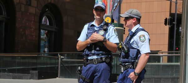 Police stand near a police line to stop pedestrian access close to a cafe under siege at Martin Place in Sydney, Australia, Monday, Dec. 15, 2014 - Sputnik International