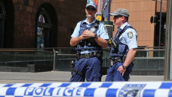 Police stand near a police line to stop pedestrian access close to a cafe under siege at Martin Place in Sydney, Australia, Monday, Dec. 15, 2014 - Sputnik International