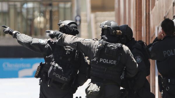 Armed police officers point as they stand at the ready close to a cafe under siege at Martin Place in Sydney, Australia, Monday, Dec. 15, 2014 - Sputnik International