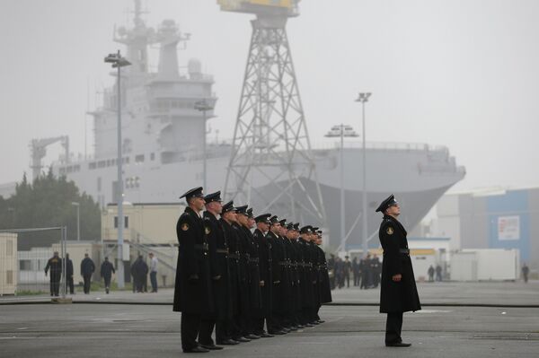 Russian sailors stand in formation in front of the Mistral-class helicopter carrier Vladivostok at the STX Les Chantiers de l'Atlantique shipyard site in Saint-Nazaire - Sputnik International