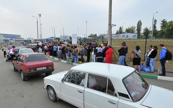 Ukrainian refugees line up to return to their homes in eastern Ukraine at the Russia-Ukraine border  - Sputnik International