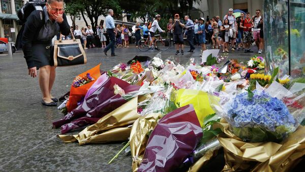 A woman reacts after placing a floral tribute for those who died in the Sydney cafe siege, near the site of the incident, in Martin Place December 16, 2014 - Sputnik International