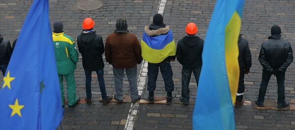 Pro-European Union activists stand guard at a barricades under EU, left, and Ukrainian national flags - Sputnik International