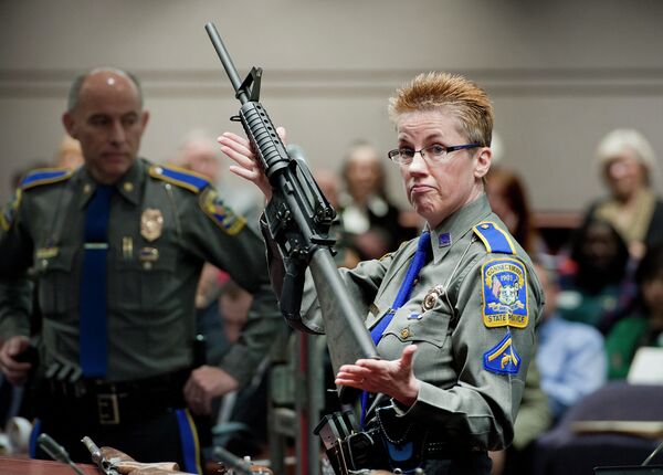 In this Jan. 28, 2013, file photo, firearms training unit Detective Barbara J. Mattson, of the Connecticut State Police, holds up a Bushmaster AR-15 rifle, the same make and model of gun used by Adam Lanza in the Sandy Hook School shooting, for a demonstration during a hearing of a legislative subcommittee reviewing gun laws, at the Legislative Office Building in Hartford, Connecticut. - Sputnik International