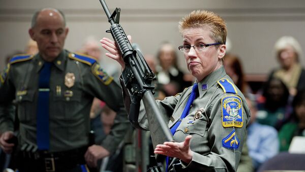 In this Jan. 28, 2013, file photo, firearms training unit Detective Barbara J. Mattson, of the Connecticut State Police, holds up a Bushmaster AR-15 rifle, the same make and model of gun used by Adam Lanza in the Sandy Hook School shooting, for a demonstration during a hearing of a legislative subcommittee reviewing gun laws, at the Legislative Office Building in Hartford, Connecticut. - Sputnik International